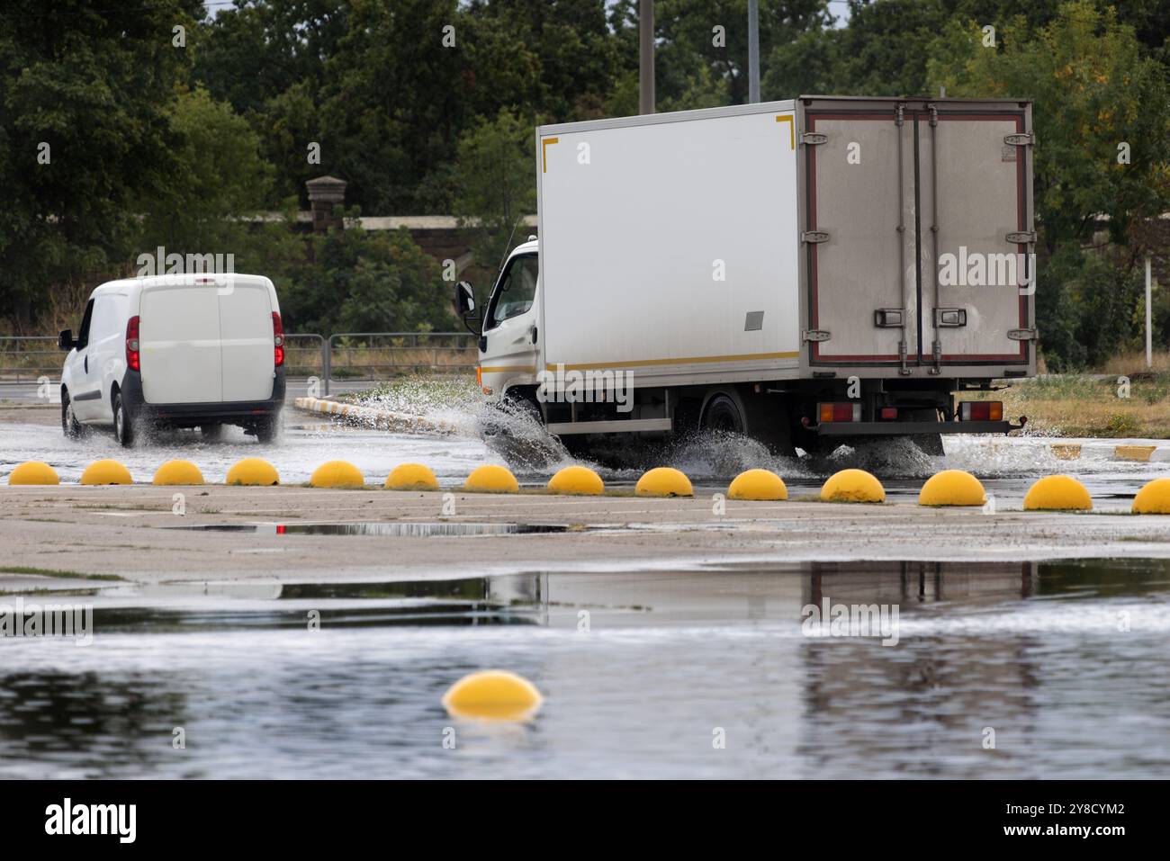 Dopo forti piogge, ingorghi stradali si sono formati, le automobili sono bagnate di acqua e stallo. Le auto galleggiano in pozzanghere sulle strade, schizzi. Crollo della strada a poppa Foto Stock