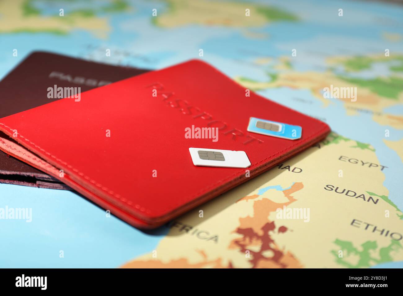 Schede SIM e passaporti moderni sulla mappa del mondo, primo piano Foto Stock