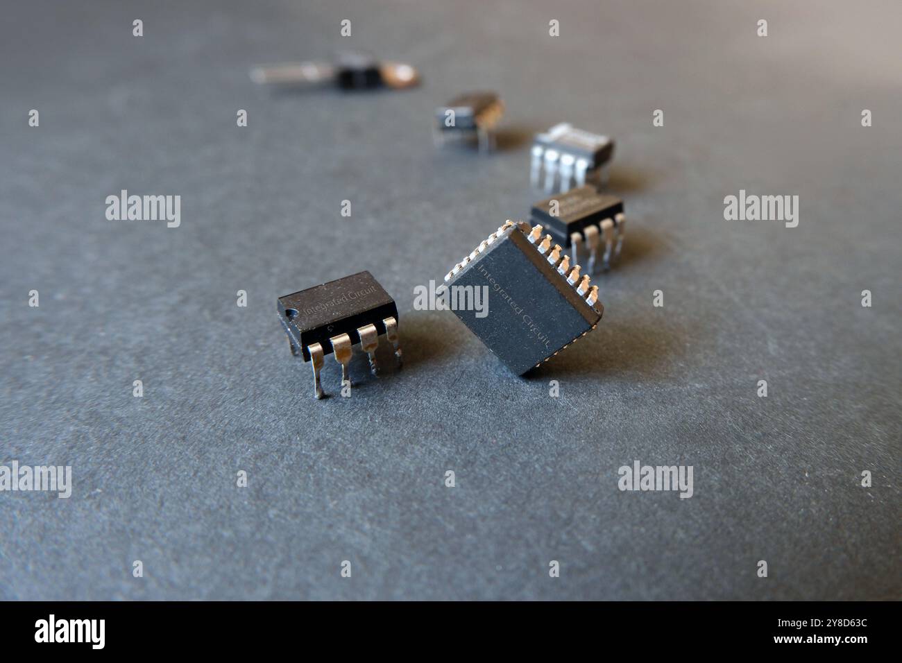 Vari circuiti integrati su una superficie scura. Componenti elettronici a semiconduttore per l'industria. Foto Stock