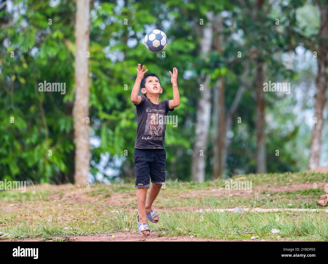 Un ragazzo gioca a calcio in un villaggio remoto. Perù, Sud America. Foto Stock