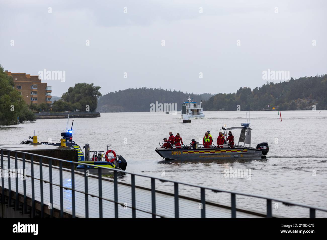 Imbarcazioni di soccorso su un fiume con personale di emergenza in uniformi rosse, tempo nuvoloso. Foto Stock