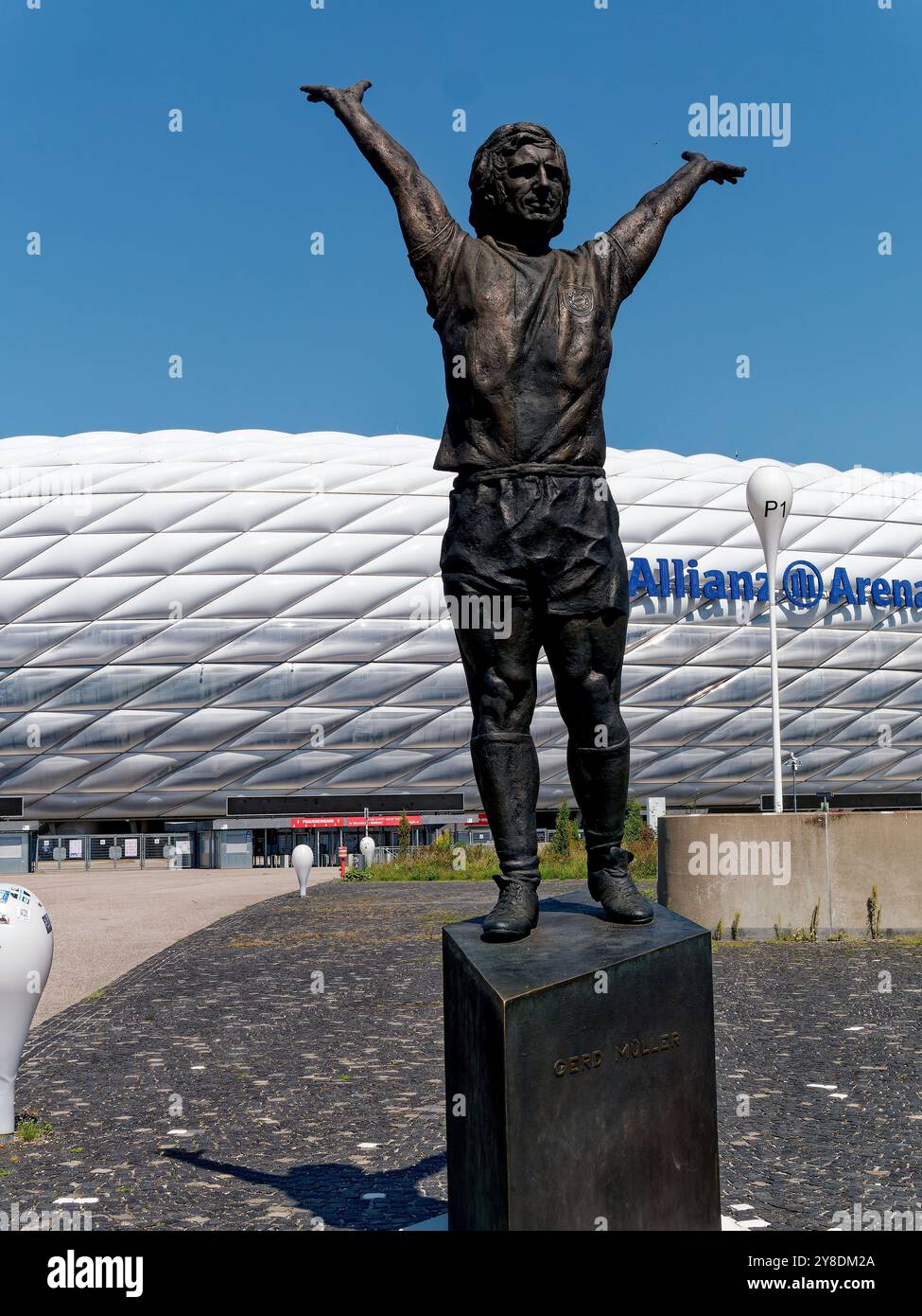Monaco di Baviera, Germania - 13 agosto 2024. Allianz Arena di Monaco sullo sfondo. Statua del calciatore Gerd Mueller in primo piano, vista esterna. Foto Stock