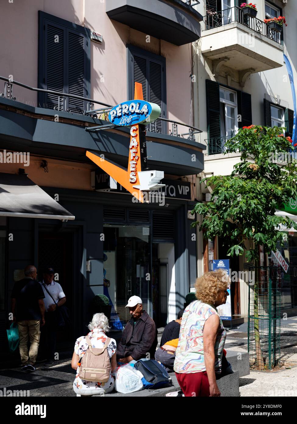 Vivace insegna del caffè e vita di strada a Funchal, con la gente del posto che si gode una giornata di sole Foto Stock