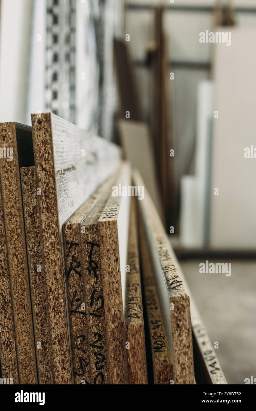 Vista ravvicinata di una pila di pannelli in legno, che mostrano la grana testurizzata e le marcature che ne indicano l'uso previsto nella produzione di mobili. Foto Stock