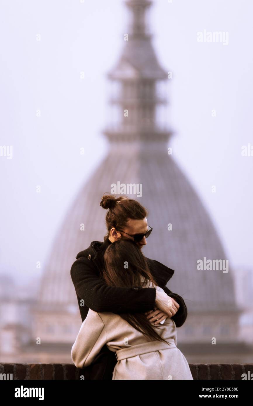 Un paio di abbracci di fronte alla Mole Antonelliana, il punto di riferimento di Torino, Piemonte, Italia. Foto Stock