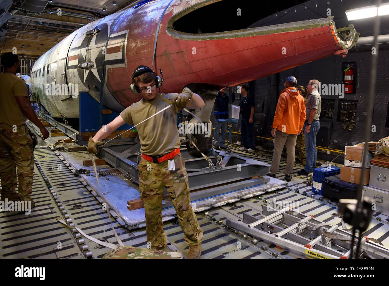 Gli aviatori con il 709th Airlift Squadron fuori dalla dover Air Force base, Delaware, finiscono di mettere in sicurezza l'interno di un aereo C-5 mentre il personale del Museum of Aviation controlla la fusoliera di un C-47A trasportato dall'Alaska fino a Robins AFB, Georgia, 19 luglio 2024. Il movimento dell'aereo fu uno sforzo multi-team tra la Joint base Elmendorf-Richardson, Alaska, dover AFB e Robins AFB per spostare il C-47A da Wasilla, Alaska, al suo ultimo luogo di riposo presso il Museum of Aviation, dove sarà sottoposto a un restauro completo e sarà esposto. (Foto U.S. Air Force di Tommie Horton) Foto Stock