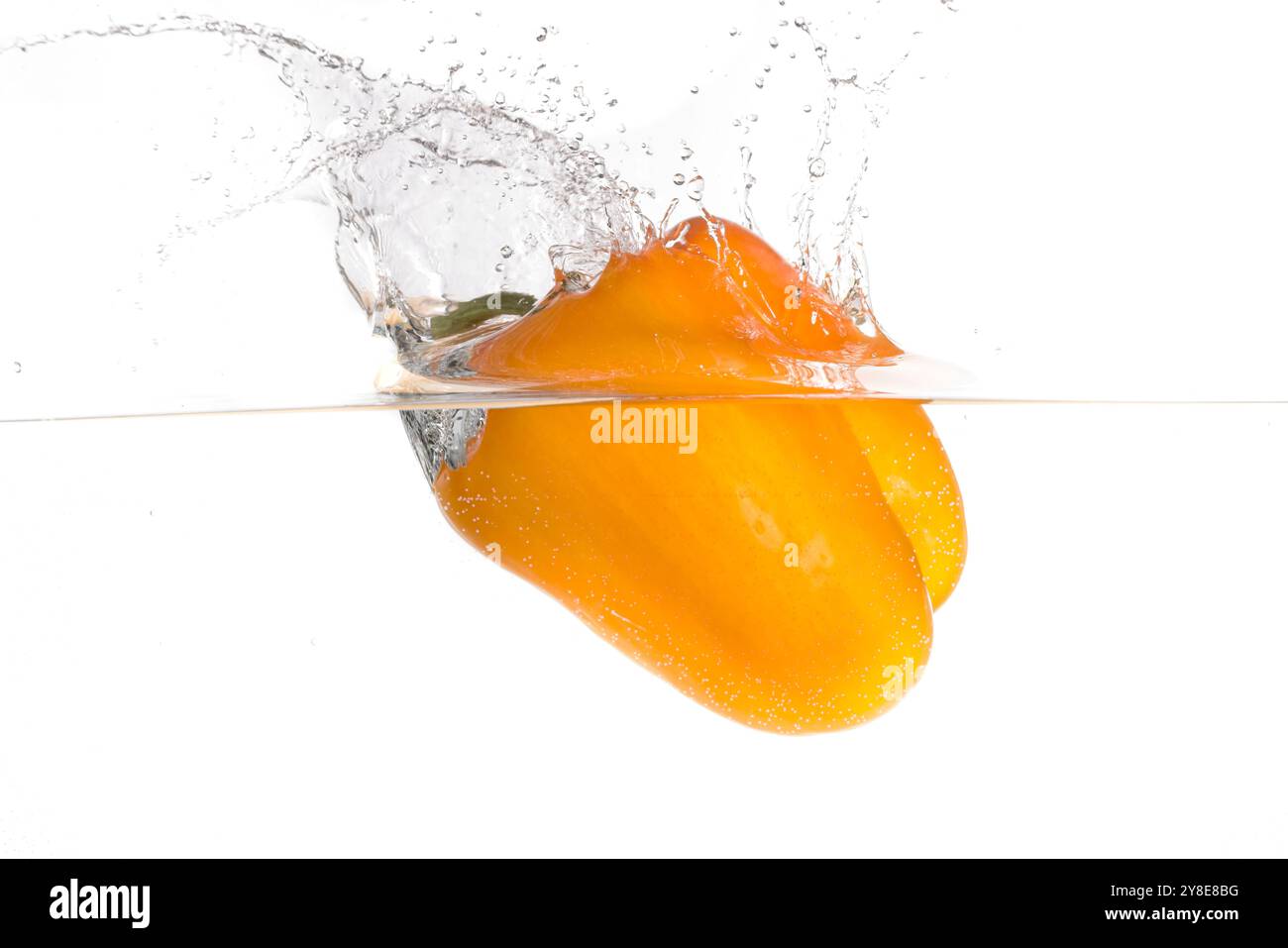 Un grande peperone d'arancia che fa un tuffo dopo essere stato lasciato in acqua in questa foto dello studio. Foto Stock