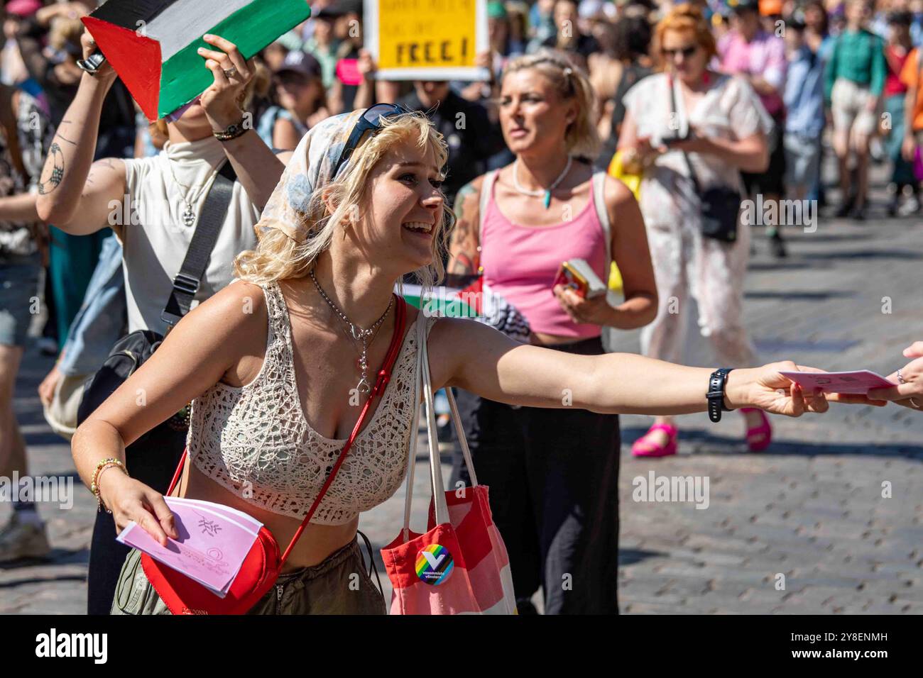 Attivista pro-palestinese che distribuisce volantini alla parata Helsinki Pride 2024 su Mannerheimintie a Helsinki, Finlandia Foto Stock