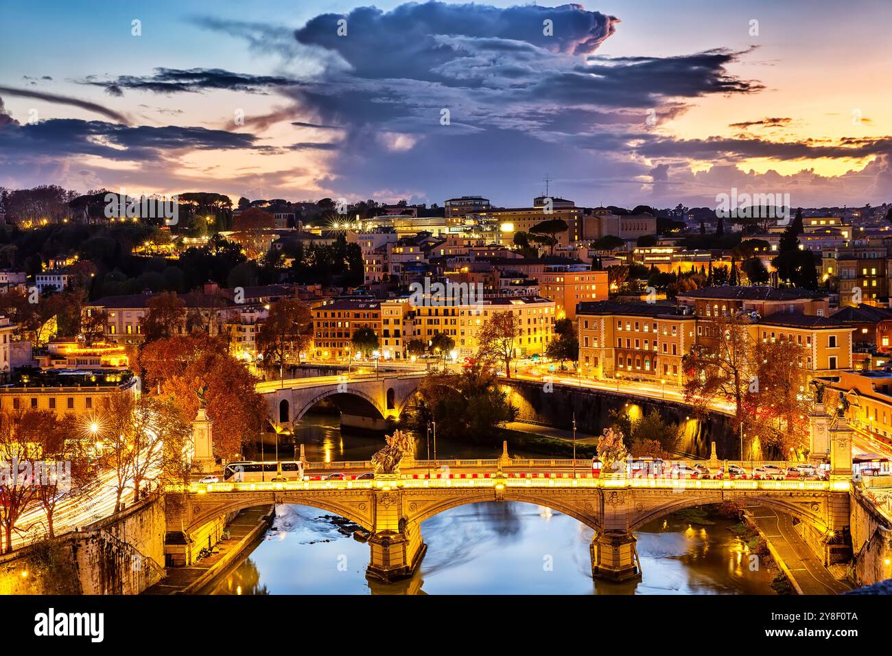 Vista aerea della città di Roma di notte, Italia. Vista dall'alto del Ponte Vittorio Emanuele II e del Ponte Principe Amedeo Savoia Ponte Aosta al tramonto a Rom Foto Stock