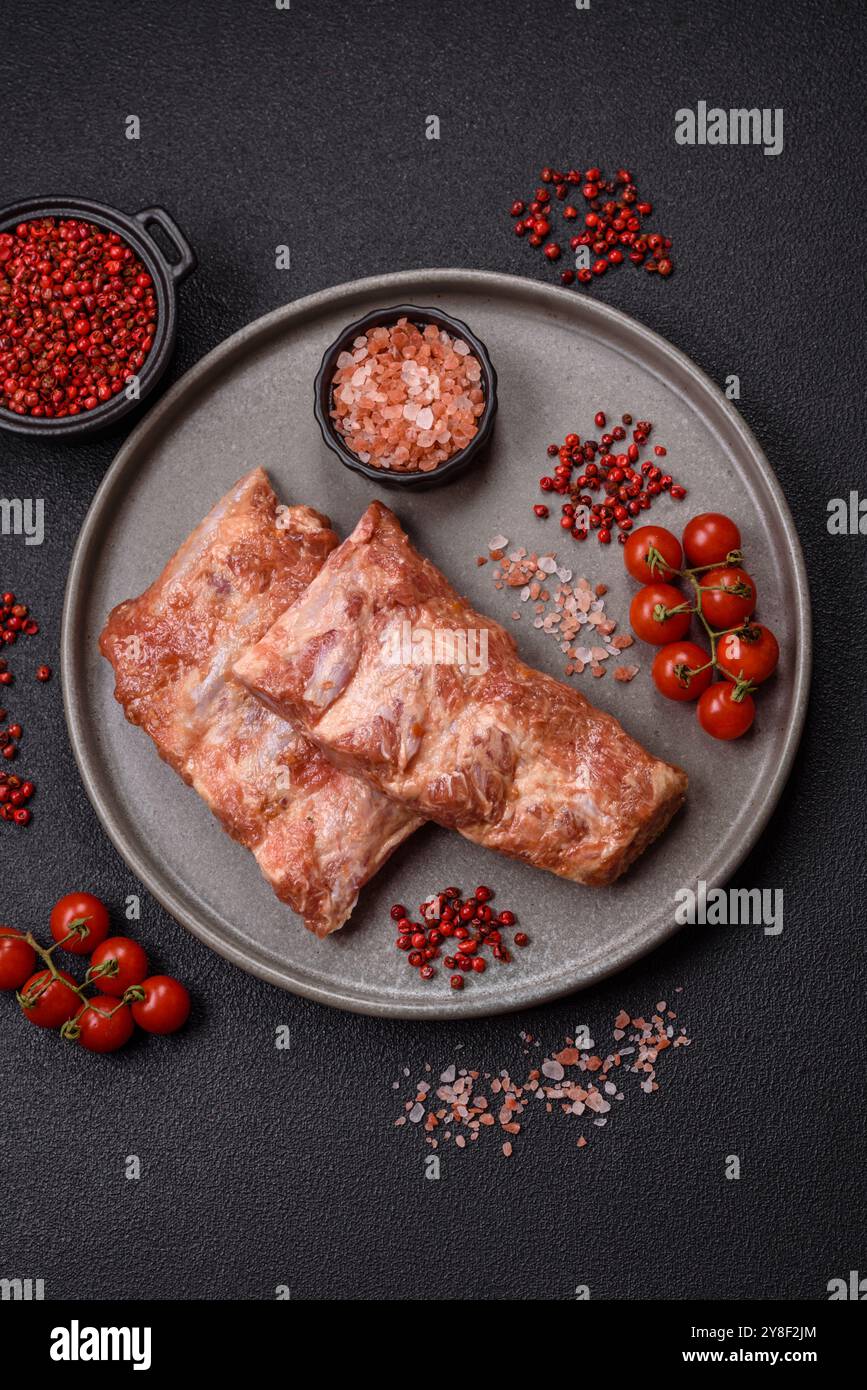 Costolette di maiale in salsa agrodolce con sale, spezie ed erbe preparate per la cottura alla griglia Foto Stock