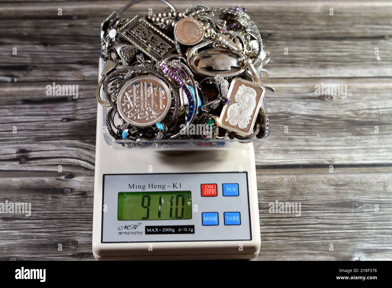 Cairo, Egitto, 7 settembre 2024: Pila d'argento su scala digitale Ming Heng K1, bracciali, anelli e catene, bar, medaglia, rosario, concetto di prezzo, precio Foto Stock
