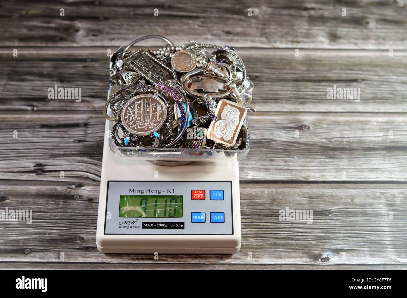 Cairo, Egitto, 7 settembre 2024: Pila d'argento su scala digitale Ming Heng K1, bracciali, anelli e catene, bar, medaglia, rosario, concetto di prezzo, precio Foto Stock