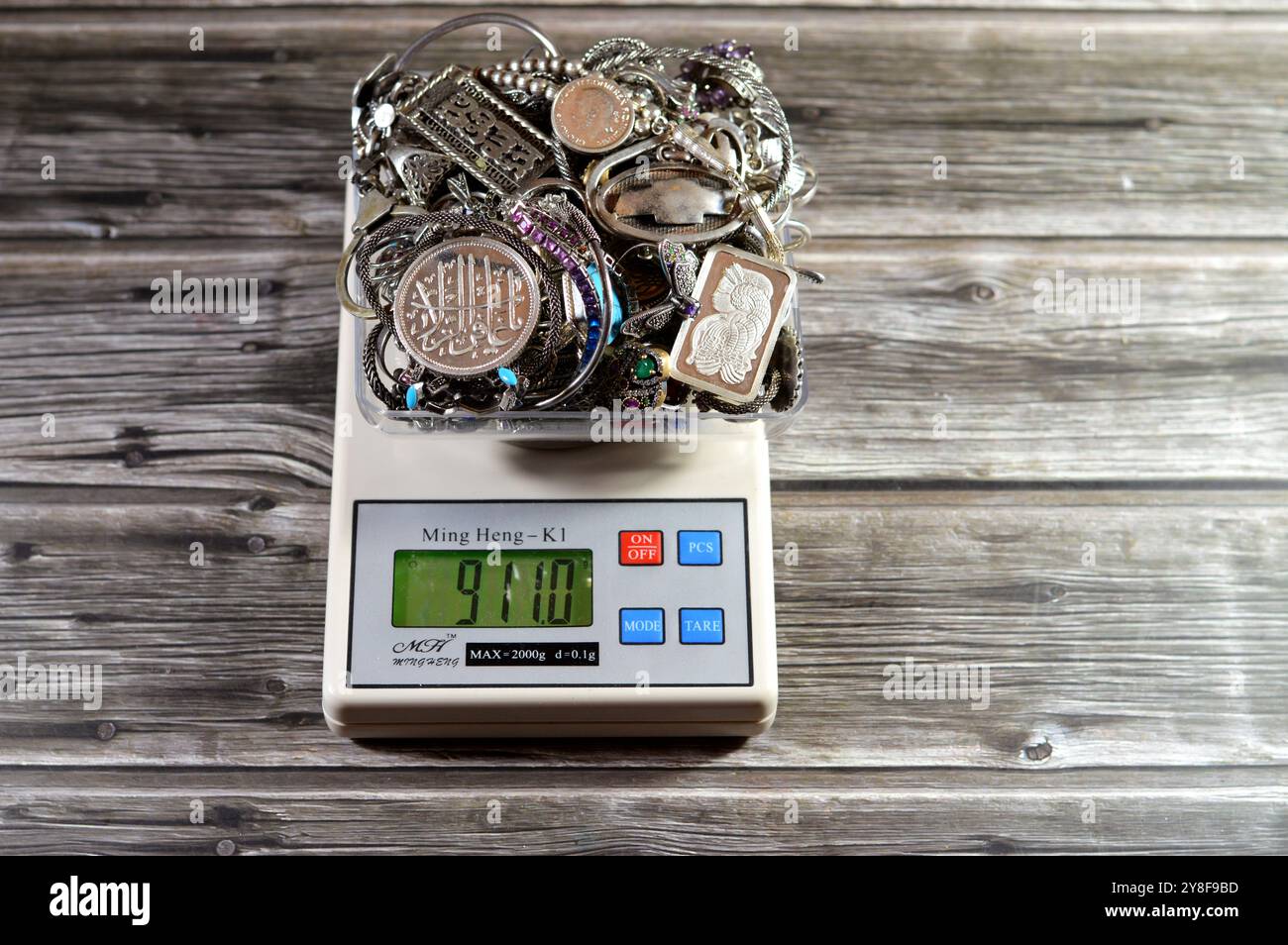 Cairo, Egitto, 7 settembre 2024: Pila d'argento su scala digitale Ming Heng K1, bracciali, anelli e catene, bar, medaglia, rosario, concetto di prezzo, precio Foto Stock