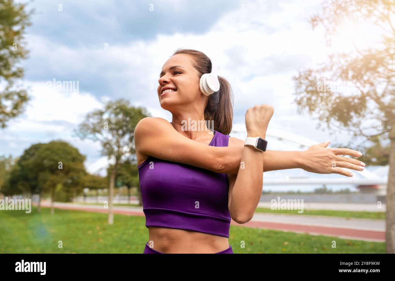 Bella donna in forma fisica che si allena all'aperto, si allunga il corpo, si fa uno stile di vita attivo. Foto Stock