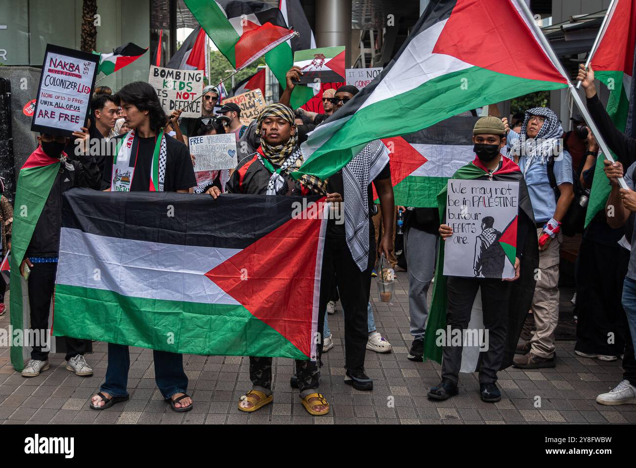 Bangkok, Thailandia. 5 ottobre 2024. I manifestanti hanno dei cartelli e delle bandiere palestinesi durante la manifestazione sulla Sukhumvit Road a Bangkok. Manifestanti pro-palestinesi che marciano sulla strada di Sukhumvit a Bangkok, Thailandia, per dimostrare solidarietà ai palestinesi e celebrare un anno delle operazioni israeliane nella Striscia di Gaza e chiedere un cessate il fuoco permanente. (Foto di Peerapon Boonyakiat/SOPA Images/Sipa USA) credito: SIPA USA/Alamy Live News Foto Stock