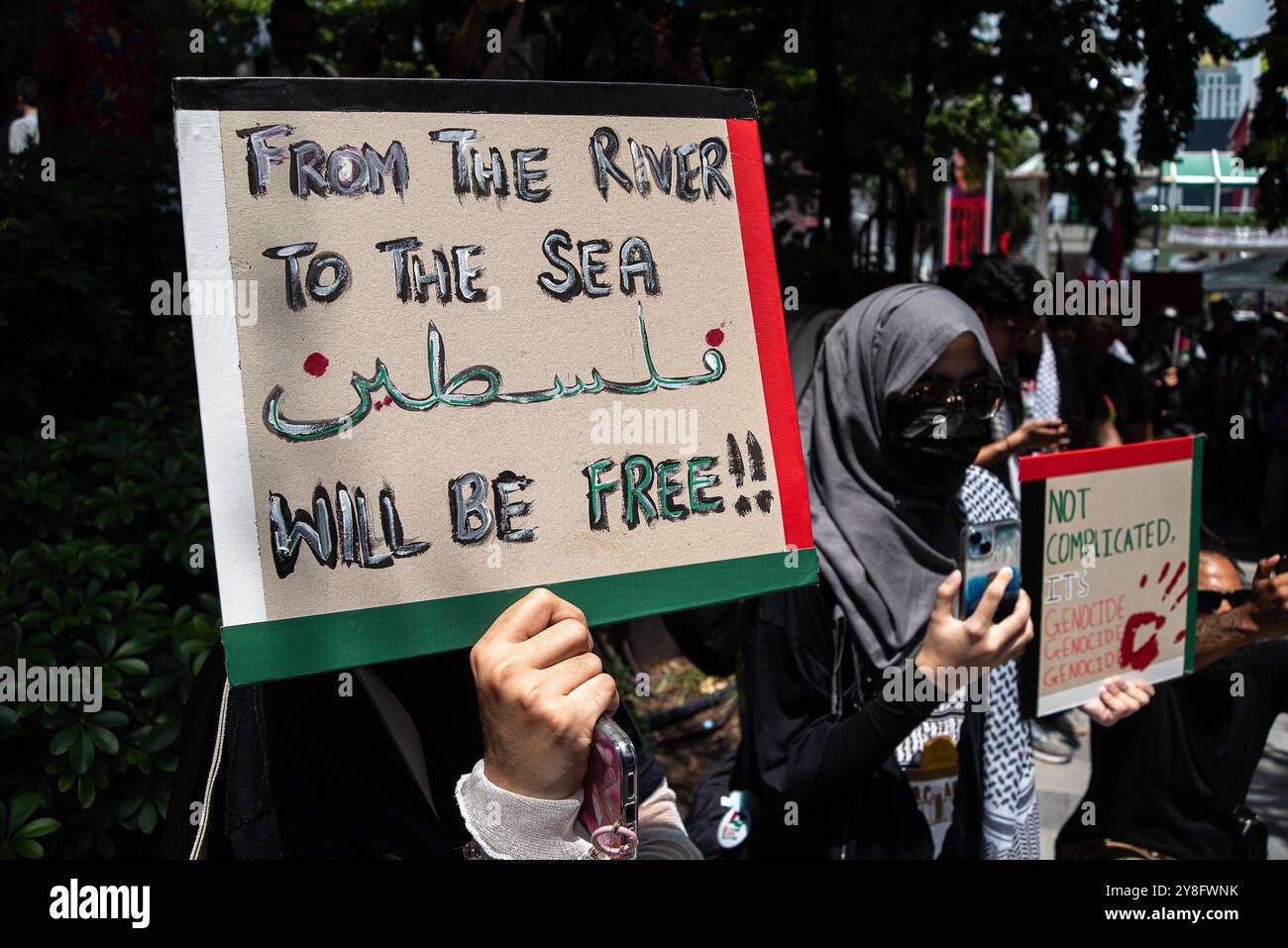 Bangkok, Thailandia. 5 ottobre 2024. I manifestanti hanno cartelli che esprimono le loro opinioni durante la manifestazione sulla strada Sukhumvit a Bangkok. Manifestanti pro-palestinesi che marciano sulla strada di Sukhumvit a Bangkok, Thailandia, per dimostrare solidarietà ai palestinesi e celebrare un anno delle operazioni israeliane nella Striscia di Gaza e chiedere un cessate il fuoco permanente. (Foto di Peerapon Boonyakiat/SOPA Images/Sipa USA) credito: SIPA USA/Alamy Live News Foto Stock