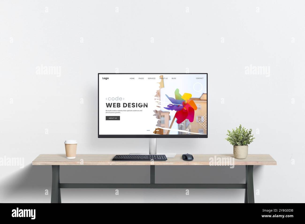 Area di lavoro per la progettazione Web pulita con display del computer sulla scrivania, sulla pianta e accanto alla tazza da caffè. Scena minimalista ideale per la presentazione in studio di web design Foto Stock