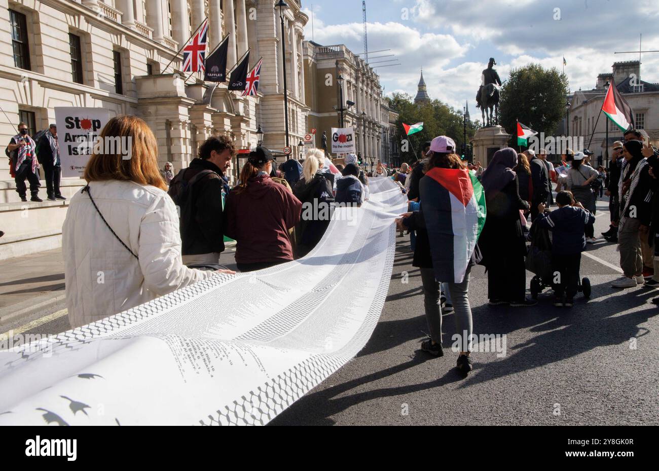 Londra, Regno Unito. 5 ottobre 2024. Genitori e bambini portano con sé una lunga lista dei nomi dei bambini palestinesi uccisi nel conflitto di Gaza finora. Marcia per la Palestina. I sostenitori della Palestina marciano per la fine della guerra a Gaza. Si stima che circa 41.000 persone siano state uccise a Gaza, con circa la metà bambini. I chiedono un cessate il fuoco immediato e la fine degli attacchi contro il Libano. La controdimostrazione israeliana chiede il rilascio immediato degli ostaggi dopo il massacro del 7 ottobre. Crediti: Karl Black/Alamy Live News Foto Stock