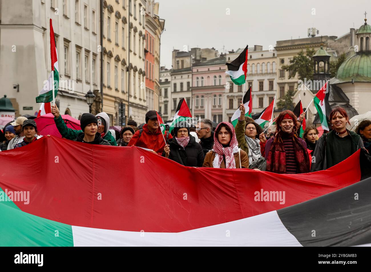I palestinesi, i libanesi e i loro sostenitori protestano a sostegno della Palestina e contro le azioni di guerra israeliane nella Striscia di Gaza, in Cisgiordania e in Libano nella piazza principale della città vecchia di Cracovia. Si vedono bandiere della Palestina e cartelli pro-Palestina. Foto Stock