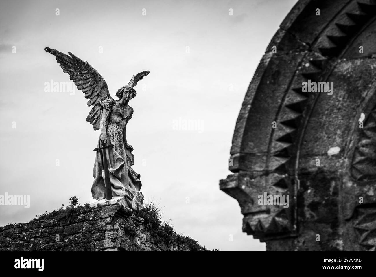 Dettagli dell'antico cimitero storico in pietra di Comillas, una statua d'angelo che si affaccia sull'oceano, Cantabria, Spagna Foto Stock