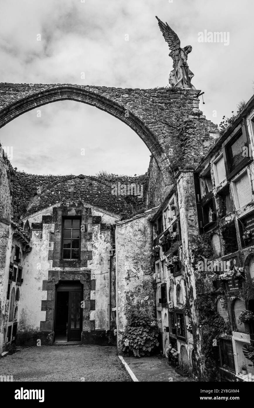 Dettagli dell'antico cimitero storico in pietra di Comillas, una statua d'angelo che si affaccia sull'oceano, Cantabria, Spagna Foto Stock