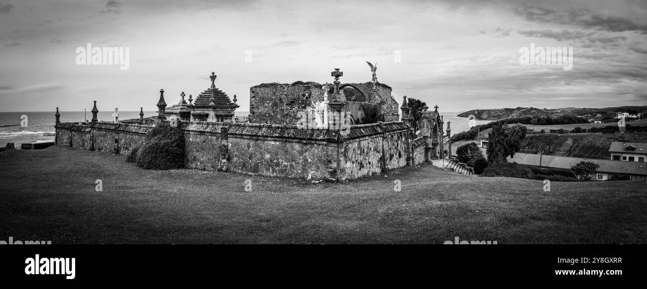 Tranquillo e storico cimitero in pietra con sculture intricate e statue di angelo che si affacciano sull'oceano, situato a Comillas, sull'oceano Atlantico Foto Stock