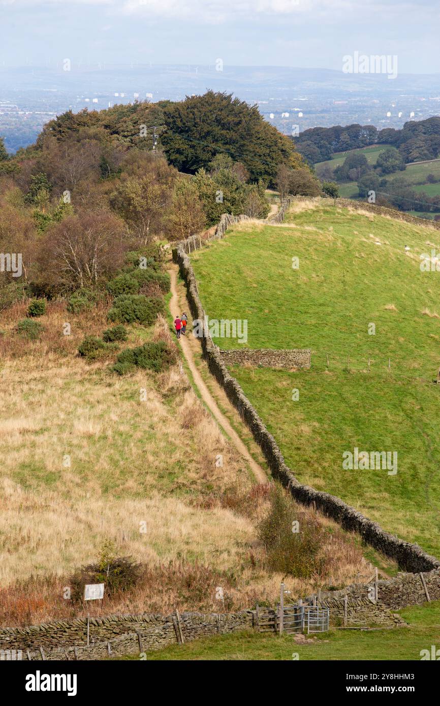Camminatore solitario che cammina sul sentiero Gritstone Trail mentre passa sopra la cresta di Kerridge vicino a Macclesfield Cheshire Foto Stock