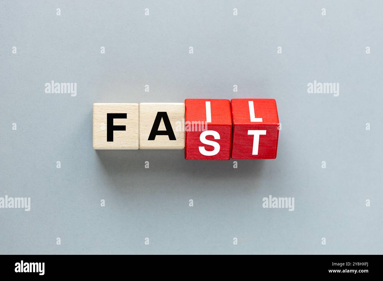 Concetto di FALLIMENTO e RAPIDITÀ. lettere su blocchi di legno che cambiano la parola "fast to fail", "concept", bellissimo sfondo grigio. disposizione piatta, spazio di copia Foto Stock