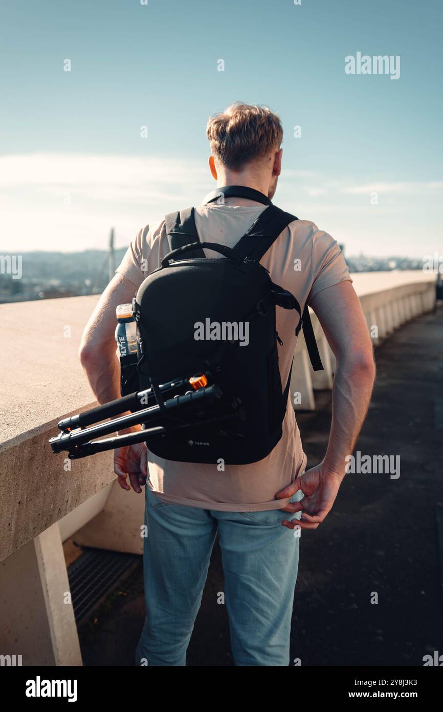 Uomo fuori dall'Estadio do Dragao che guarda su Porto, Portogallo, con zaino Foto Stock