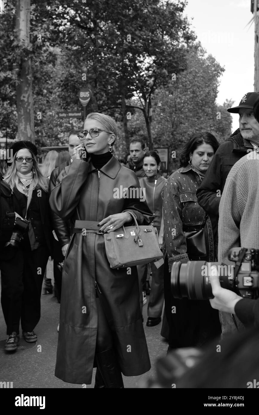 Caro Daur indossa un lungo cappotto in pelle rosso/marrone/bordeaux, un maglione con collo a tartaruga nero e occhiali da sole alla Hermès Paris Fashion Week SS25 Foto Stock