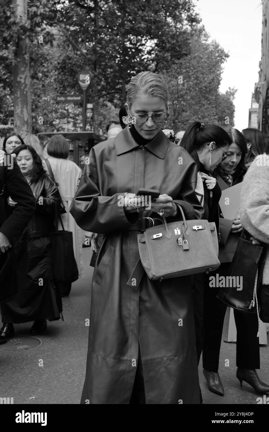 Caro Daur indossa un lungo cappotto in pelle rosso/marrone/bordeaux, un maglione con collo a tartaruga nero e occhiali da sole alla Hermès Paris Fashion Week SS25 Foto Stock