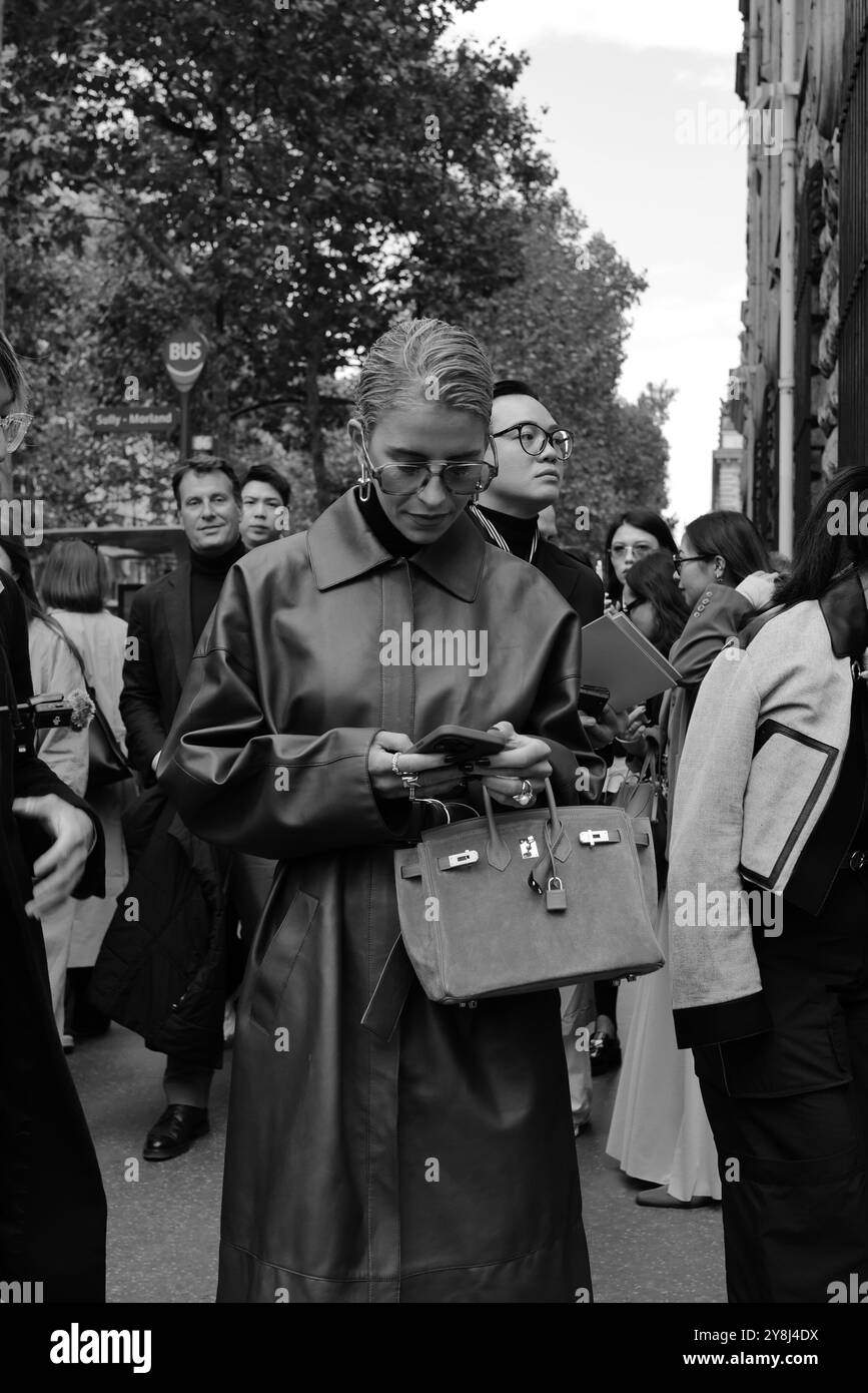 Caro Daur indossa un lungo cappotto in pelle rosso/marrone/bordeaux, un maglione con collo a tartaruga nero e occhiali da sole alla Hermès Paris Fashion Week SS25 Foto Stock