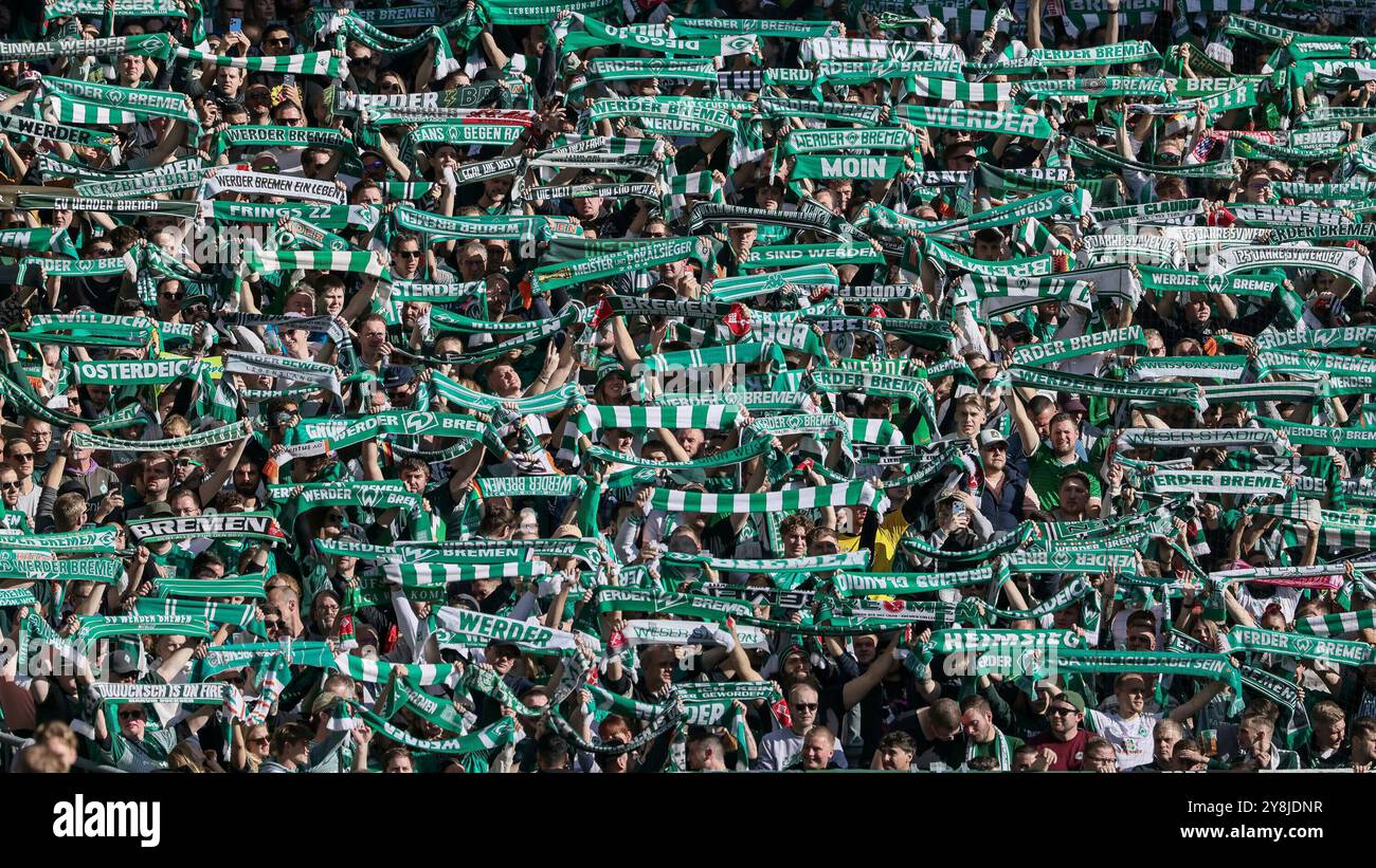 Brema, Germania. 5 ottobre 2024. v.li.: Fans des SV Werder Brema halten im Fanblock, auf der Tribüne ihre Schals, Fanschals hoch, Symbolfoto, Symbolbild Fussball, Fußball, SYMBOL, DIE DFL-RICHTLINIEN UNTERSAGEN JEGLICHE NUTZUNG VON FOTOS ALS SEQUENZBILDER UND/ODER VIDEOA? HNLICHE FOTOSTRECKEN. LE NORMATIVE DFL VIETANO QUALSIASI USO DI FOTOGRAFIE COME SEQUENZE DI IMMAGINI E/O QUASI-VIDEO., 05.10.2024, BREMA (DEUTSCHLAND), FUSSBALL, BUNDESLIGA, SV Werder Brema - SC Freiburg credito: dpa/Alamy Live News Foto Stock