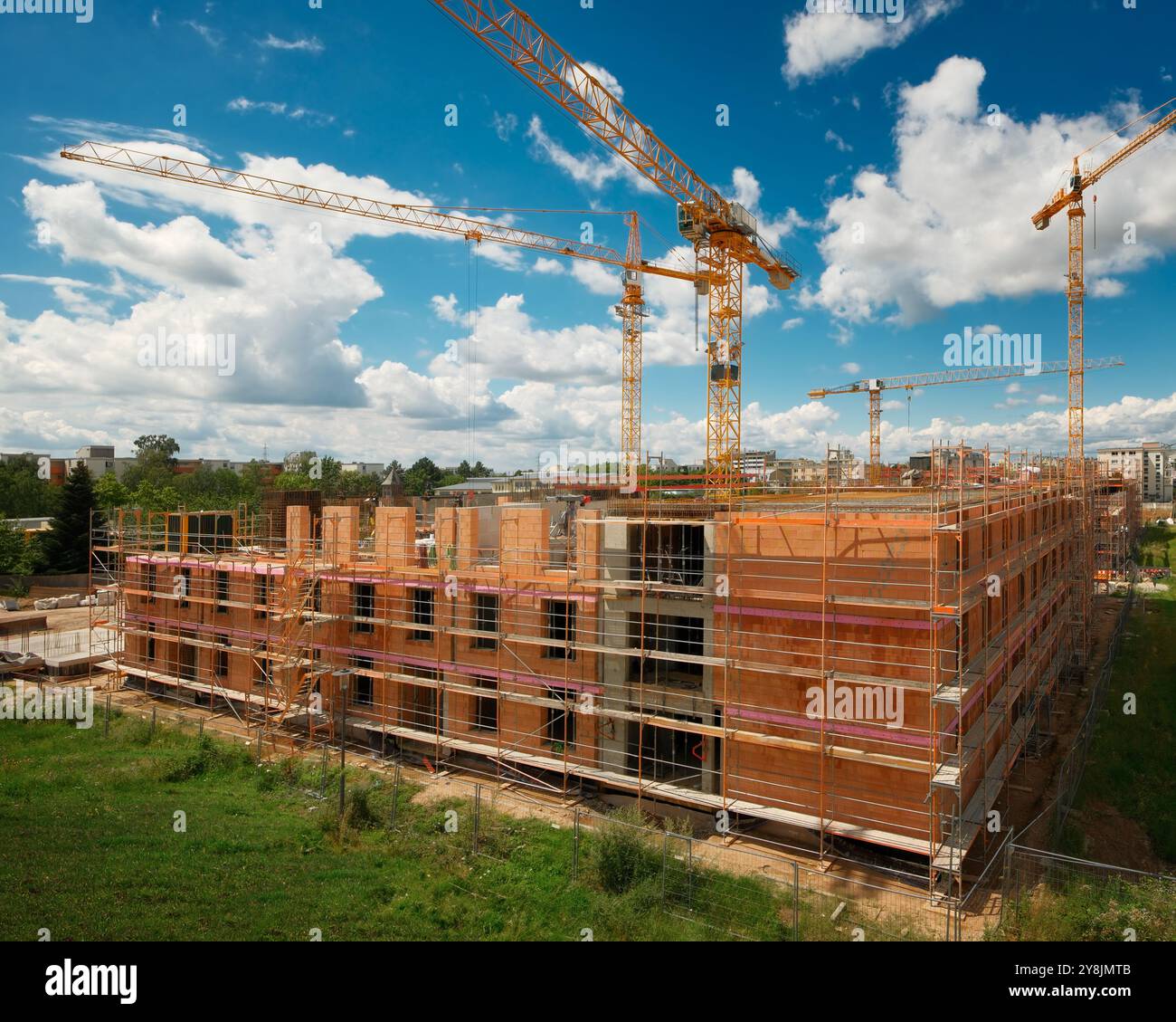 Cantiere con diverse gru sopra un bel cielo blu, senza nessuno e senza loghi Foto Stock