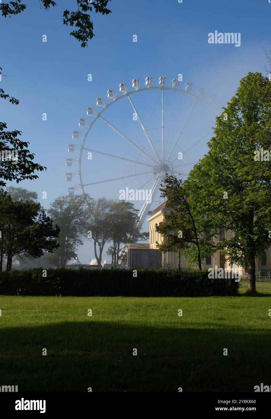 Kuehlungsborn, Germania - 30 maggio 2021: Ruota panoramica bianca dietro alberi e piante in una serata primaverile con nebbia leggera sulla costa baltica nel nord del G Foto Stock