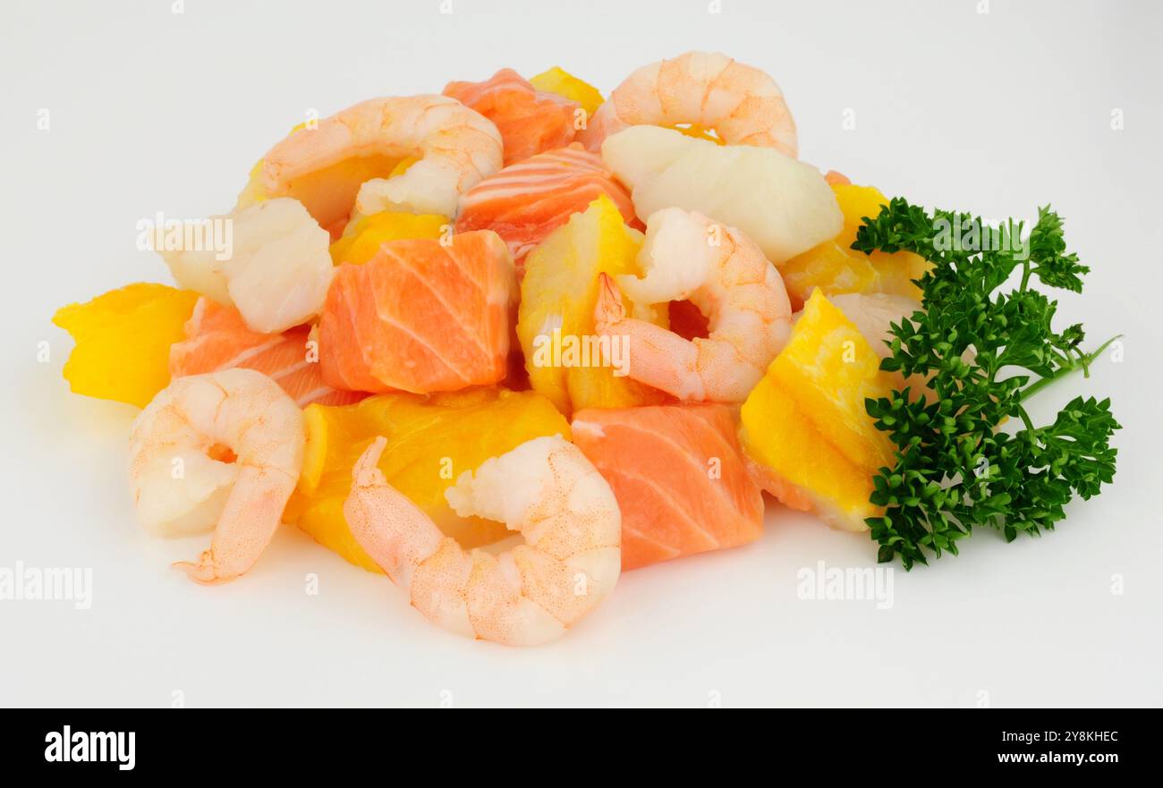Gruppo di gamberetti crudi freschi, salmone, merluzzo e pezzi di eglefino affumicati preparati per una torta di pesce Foto Stock