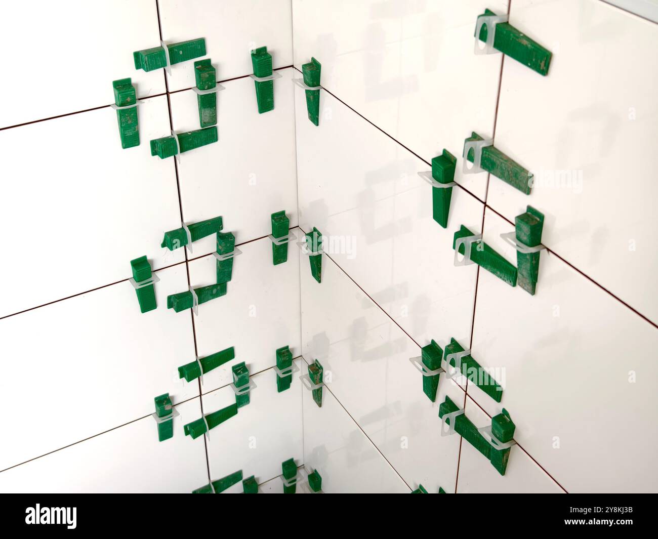 Affianca in un piccolo spazio la misurazione e la marcatura di una piastrella. Foto Stock