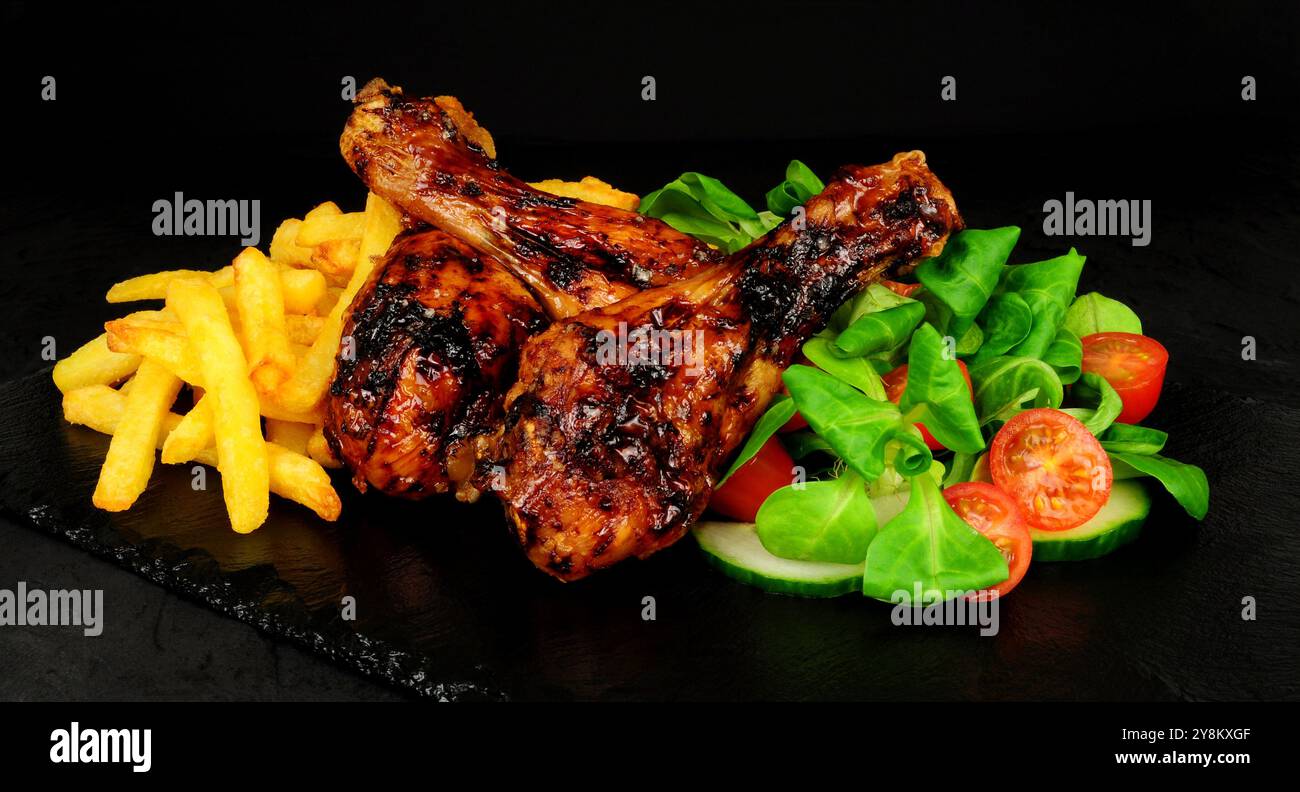 Ali di pollo alla griglia con patatine fritte e agnelli lattuga e contorno al limone Foto Stock