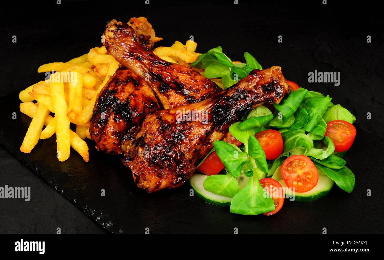 Ali di pollo alla griglia con patatine fritte e agnelli lattuga e contorno al limone Foto Stock