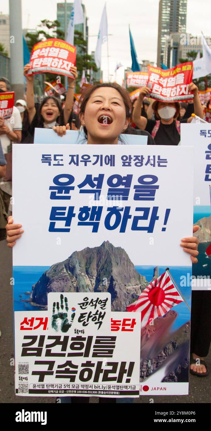 Protesta che chiede l'impeachment del presidente sudcoreano Yoon Suk-Yeol e l'arresto della first lady Kim Keon-Hee, 21 settembre 2024: I sudcoreani marciano durante una protesta che chiede l'impeachment del presidente Yoon Suk-Yeol vicino al parlamento di Seul, Corea del Sud. I partecipanti hanno chiesto l'arresto di Kim Keon-Hee, moglie del presidente Yoon, insistendo che la first lady stesse manipolando gli affari di stato. Migliaia di persone hanno partecipato alla manifestazione. Un picchetto (davanti) recita: "Impeach Yoon Suk-Yeol che conduce la danza per espellere Dokdo!" E' imprigionare Kim Keon-Hee che si e' immischiato nel parlamento Foto Stock