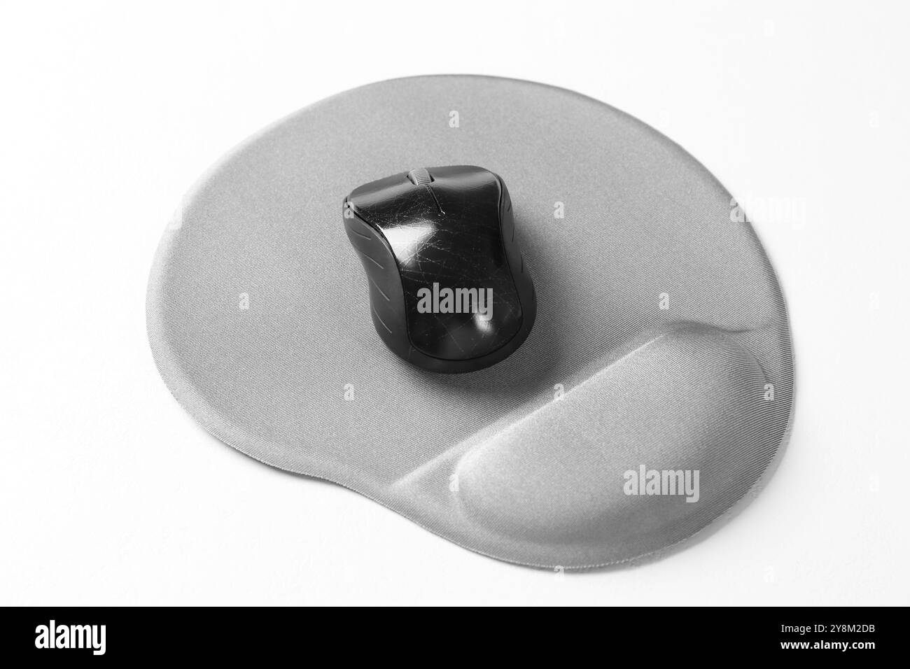 Mouse del computer e tappetino con bracciolo su tavolo bianco Foto Stock