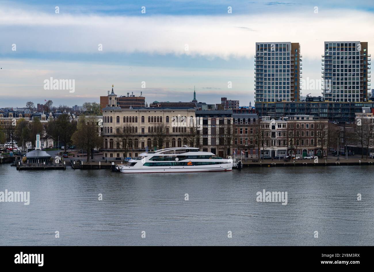 Rotterdam, Paesi Bassi - 1° aprile 2024: L'elegante barca Prinses Amalia attraccata di fronte a edifici storici e moderni lungo un fiume tranquillo, che mostra Foto Stock