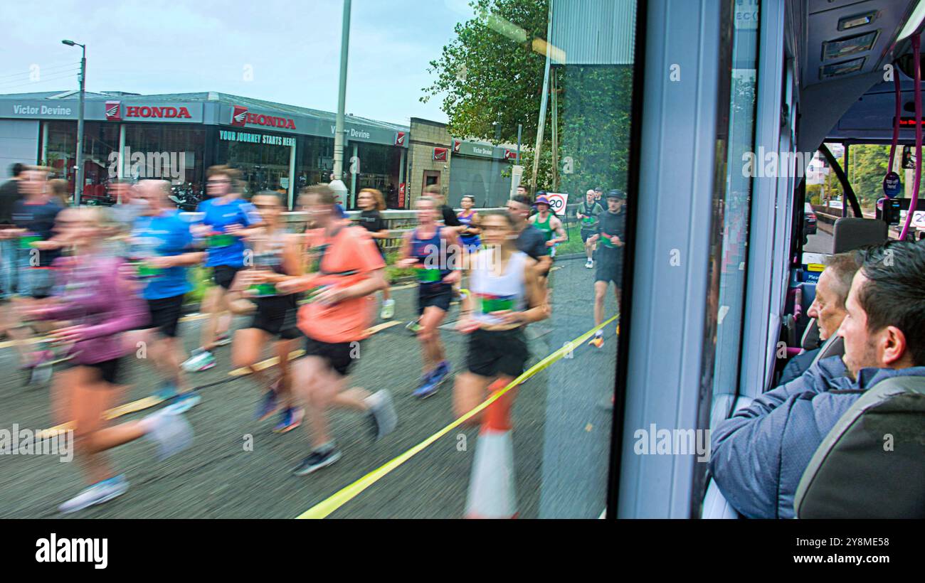 Glasgow, Scozia, Regno Unito. 6 ottobre 2024. La Great Scottish Run parte da george Square e attraversa la città. I corridori colpiscono la giungla di cemento della superstrada di clydeside mentre la corsa interrompe il treffio della città i passeggeri dell'autobus disorientato guardano. Credit Gerard Ferry/Alamy Live News Foto Stock