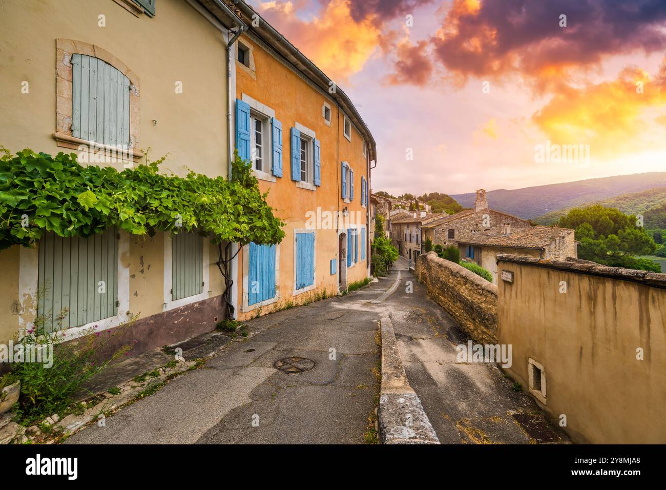 Affascinante strada nel pittoresco villaggio di Menerbes con edifici colorati e fiori vivaci. Villaggio di Menerbes (il più bel villaggio in Francia) nel Foto Stock