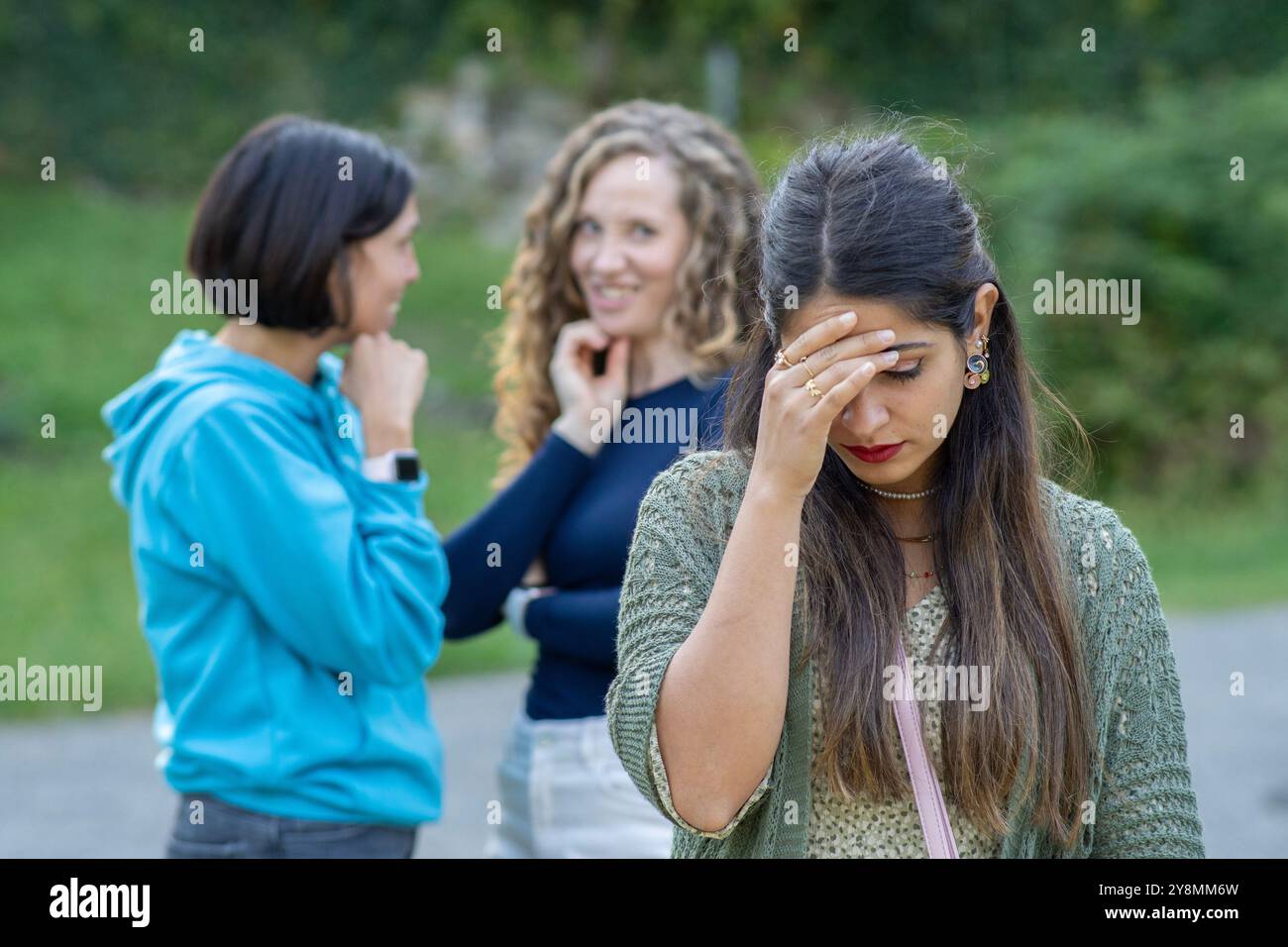 Falsi amici sullo sfondo fingono di essere tristi amici in primo piano. Falsa idea di amicizia Foto Stock