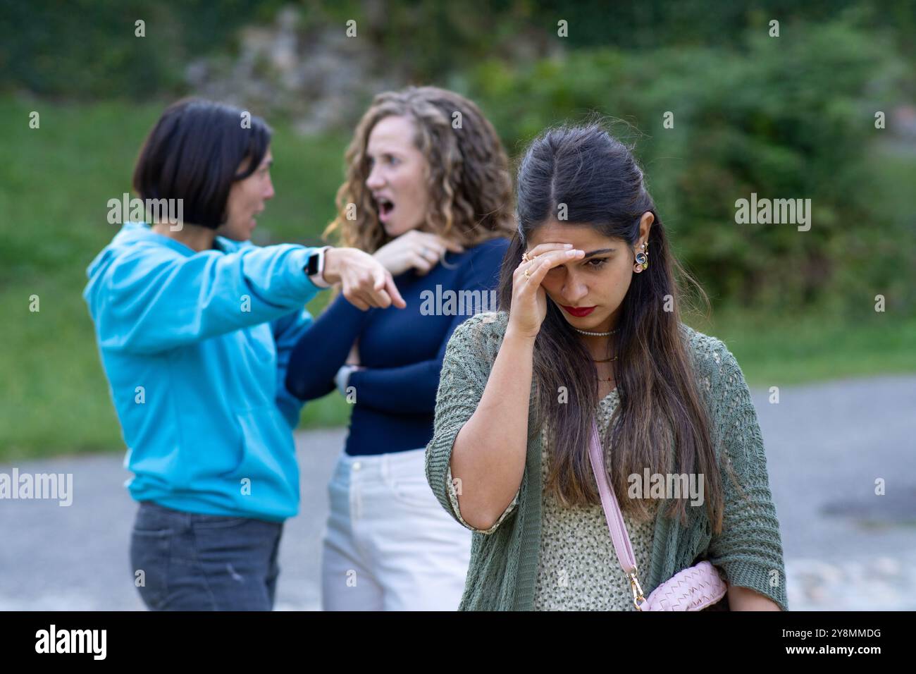 Falsi amici sullo sfondo fingono di essere tristi amici in primo piano. Falsa idea di amicizia Foto Stock