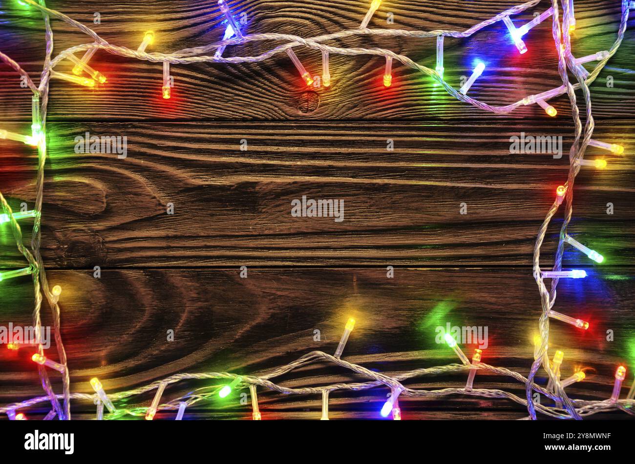 Le luci di Natale sul legno scuro dello sfondo laici piana mockup telaio per il biglietto di auguri Foto Stock