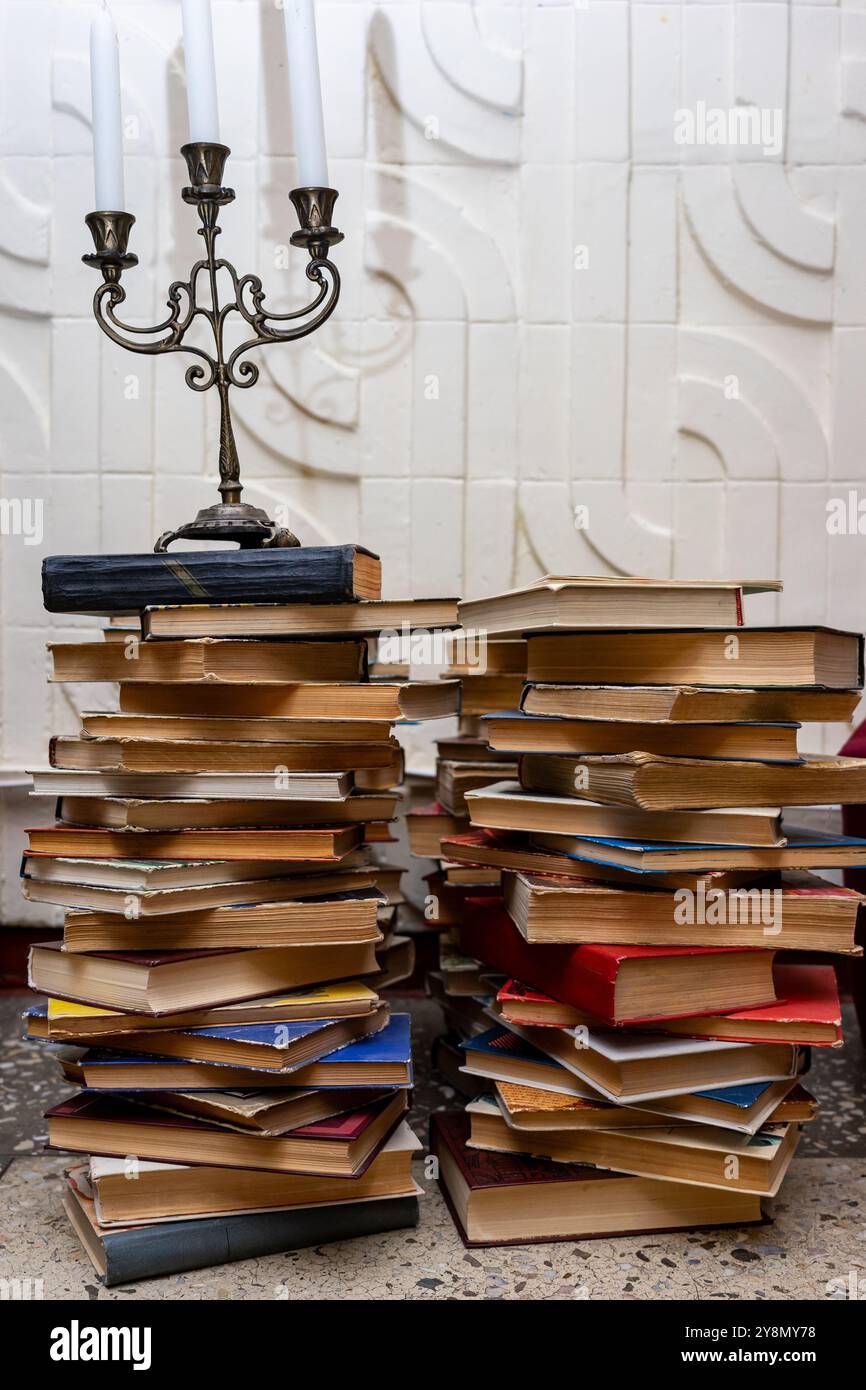 Antico candelabro su una torre di libri. Foto Stock