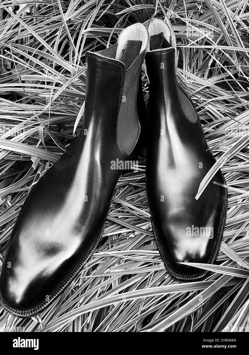Stivali Chelsea Premium German Black su misura. Liscia con cinghie, ripresa su sfondo erboso all'aperto. Foto Stock