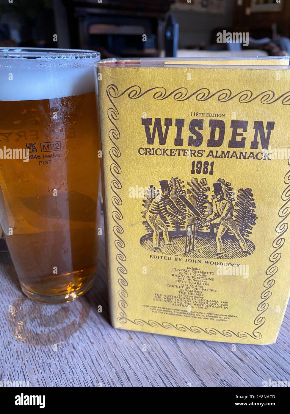 Widsen cricketers versione almanack 1981 accanto a una pinta di birra inglese in un pub del Lancashire, Inghilterra, Regno Unito Foto Stock